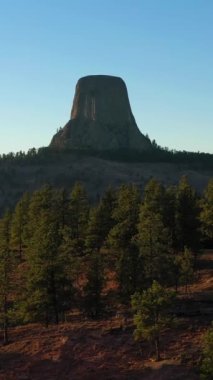Sonbaharda Sunset 'te Devils Tower Butte. Crook County 'de. Wyoming, ABD. Hava görüntüsü. İnsansız hava aracı alçaktan uçuyor. Dikey Video