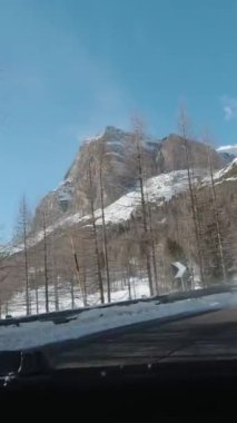 Güneşli kış gününde İtalya 'da Dolomitlerde araba sürmek. Kar, Orman ve Dağlar. Dikey Video