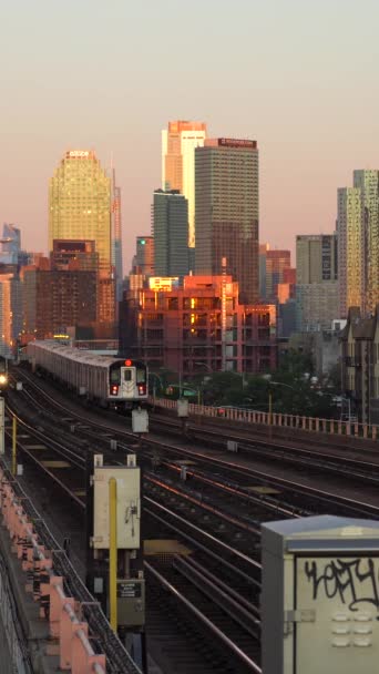 ニューヨークシティ アメリカ October 2021 クイーンズの日の出に通過する高架線7地下鉄 マンハッタン スカイラインビュー バーティカルビデオ — ストック動画