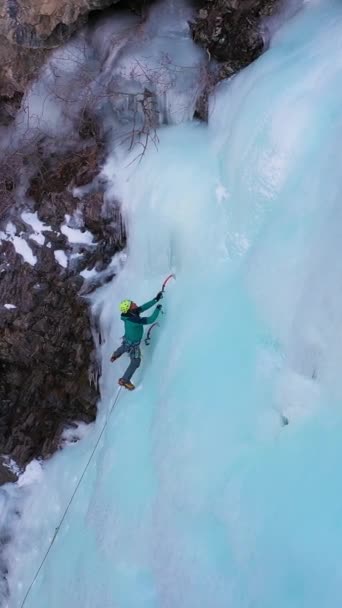 Wspinaczka Zamarzniętym Wodospadzie Widok Powietrza Alpinista Umieszcza Śrubę Lodową Dolina — Wideo stockowe