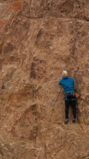 人类攀岩攀岩 哈萨克斯坦坦加利塔斯的悬崖 空中景观 无人机向上飞 向下倾斜 起重机中弹 垂直录像 — 图库视频影像