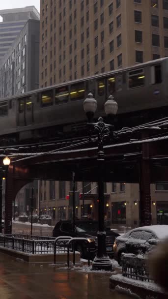 チカゴ アメリカ January 2021 曇りの日にシカゴループでシカゴL列車を上昇させました スノーウィング コロナウイルスのパンデミック中にマスクを着用している人 バーティカルビデオ — ストック動画