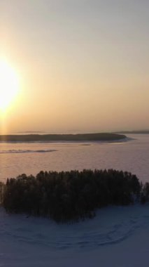 Donmuş Kandalaksha Körfezi ve Ağaç Adaları Kış Gününde. Hava görüntüsü. Murmansk Bölgesi, Rusya. Yörüngede. Dikey Video