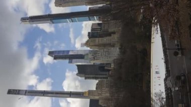 İnsanlar güneşli bir günde Central Park 'ta buz pateni pistinde buz pateni yapıyorlar. Şehir merkezi şehir manzarası. - Manhattan. New York City, ABD. Zaman aşımı. Dikey Video