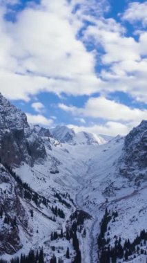 Güneşli bir günde Tuyuksu 'nun Karlı Dağları. Kuzey Tian Shan. Kazakistan. Hava Hızı Hızı, Zaman Hızı. Drone İleri Uçuyor. Dikey Video