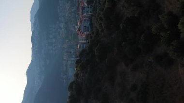 Güneşli bir günde Kas Kasabası, Deniz ve Dağların Beyaz Evleri. Antalya, Türkiye. Hava görüntüsü. Drone ileri ve yukarı doğru uçuyor. Şutu göster. Dikey Video