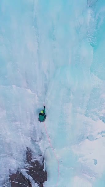 冰封瀑布上的冰 空中自上而下的观点 人是领导冰 吉尔吉斯斯坦的Barskoon Valley 飞行员向前飞 向下倾斜 垂直录像 — 图库视频影像