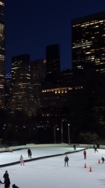NEW YORK CITY, ABD - 22 HAZİRAN 2021: Coronavirus salgını sırasında Central Park 'ta Wollman Paten Pisti' nde Maske Giyen İnsanlar. Manhattan Şehri manzarası. Dikey Video
