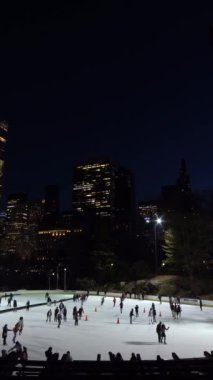 NEW YORK CITY, ABD - 22 HAZİRAN 2021: Coronavirus salgını sırasında Central Park 'ta Wollman Paten Pisti' nde Maske Giyen İnsanlar. Şehir merkezi şehir manzarası. Dikey Video