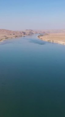 Güneşli günde Ili Nehri ve Kazak Steppe. Hava görüntüsü. Drone İleri Uçuyor, Eğil. Şutu göster. Dikey Video