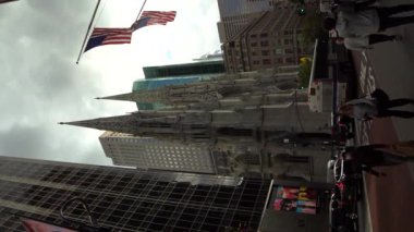 NEW YORK CITY, ABD - 29 Eylül 2021: Manhattan 'da araba trafiği ve St. Patricks Katedrali. Amerikan Bayrakları. Dikey Video