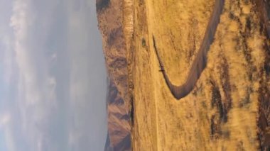 Sonbahar güneşli sabahında Kuzey Masası Dağ Parkı 'nda yürüyüş yapan iki yürüyüşçü. Hava görüntüsü. Golden, Colorado, ABD. Drone yörüngede. Dikey Video