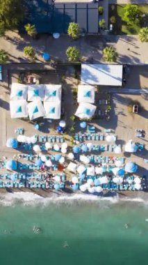 Antalya 'daki Konyaalti Plajı. Hindi. Sea ve Embankment. Havadan Yukarıdan Aşağı Görünümü. İnsansız hava aracı yandan uçuyor. Hava Hızı Hızı, Zaman Hızı. Dikey Video