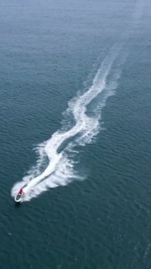 Denizde jet ski. Havadan Yukarıdan Aşağı Görünümü. Kamera Eğiliyor. Dikey Video