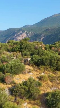 Güneşli bir günde Kas Marina, Gemiler, Yatlar, Deniz ve Dağlar. Antalya, Türkiye. Hava görüntüsü. Drone ileri ve yukarı doğru uçuyor. Şutu göster. Dikey Video
