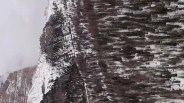 Tre Cime Di Lavaredo. Bulutlu Kış Günü ve Ormandaki Üç Tepe. Hava görüntüsü. Seksi Dolomitler, Güney Tyrol, İtalya. Drone İleri Uçuyor, Eğil. Şutu göster. Güney manzaralı. Dikey Video