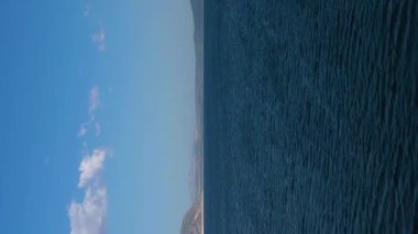 Güneşli bir günde Salda Gölü. Burdur ilinin, Türkiye. Hava görüntüsü. İnsansız hava aracı yukarı ve geri uçuyor. Dikey Video