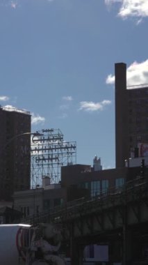 NEW YORK CITY, ABD - 24 HAZİRAN 2021: Güneşli bir günde Williamsburg 'da metro treni geçiyor. Brooklyn 'in şehir manzarası. Dikey Video