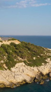 Araba sahil şeridi boyunca. Mavi Deniz. Hava görüntüsü. Hindi. Drone ileri ve yukarı doğru uçuyor. Dikey Video