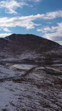 Evans Dağı 'ndaki Summit Gölü. Karlı Dağlar ve Yol. Bulutlu Gökyüzü. Hava görüntüsü. Colorado, ABD. Drone yörüngede. Dikey Video