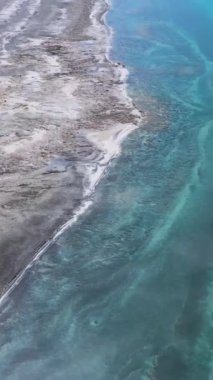 Güneşli bir günde Salda Gölü kıyısı. Mars manzarası. Burdur ilinin, Türkiye. Hava görüntüsü. Sudaki Bulutlar Yansıması. Drone İleri Uçuyor. Dikey Video