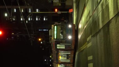 SEATTLE, ABD - 4 Şubat 2021: Tram, Road and Cityscape at Night. Araba trafiği. Dikey Video