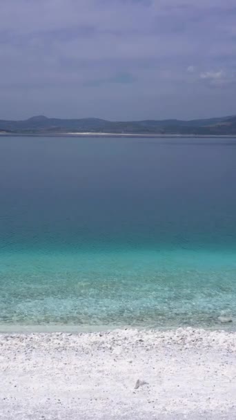 阳光灿烂的日子里 萨尔达海岸湖 火山口湖 土耳其布尔杜尔省 空中景观 土耳其马尔代夫 飞行员在低层飞滑道 滑翔机射击 垂直录像 — 图库视频影像