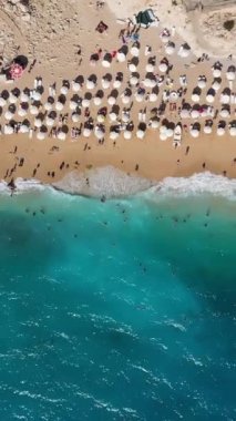 Güneşli bir günde Kaputas Plajı. Havadan Yukarıdan Aşağı Görünümü. Türk Rivierası. Hindi. İnsansız hava aracı yandan uçuyor. Dikey Video