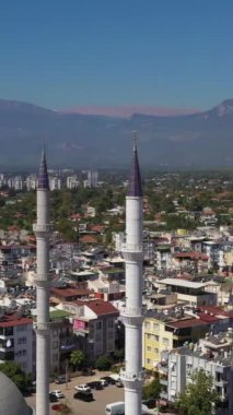 Cami, şehir ve dağların minareleri. Antalya hindisi. Hava görüntüsü. Yörüngede. Dikey Video