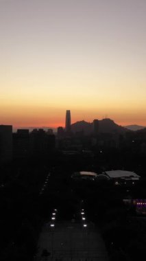 Santiago City Silhouette Sunset 'te. Hava görüntüsü. Las Condes Komünü. Şili. Drone yukarı doğru uçuyor. Dikey Video