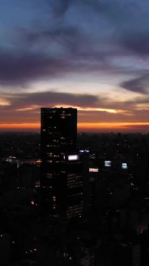 Gece vakti Buenos Aires City Skyline. Arjantin. Mavi Saat. Drone geriye doğru uçuyor. Dikey Video