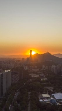 Santiago City Skyline Sunset 'te. Hava Hızı Hızı, Zaman Hızı. Las Condes Komünü. Şili. İnsansız hava aracı yandan uçuyor. Dikey Video