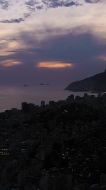 Rio de Janeiro Şehri, Gece. Ipanema Mahallesi. Akşam Alacakaranlığı. Mavi Saat. Hava görüntüsü. Brezilya. Drone İleri Uçuyor. Dikey Video