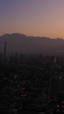 Santiago City, Sabah Alacakaranlığı ve And Dağları 'nda. Mavi Saat. Hava görüntüsü. Şili. İnsansız hava aracı yandan uçuyor. Dikey Video