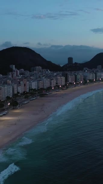 里约热内卢的晨光之城科帕卡巴纳海滩和大西洋 蓝色一小时 空中景观 飞行员向前飞 倾斜向上 真枪实弹垂直录像 — 图库视频影像