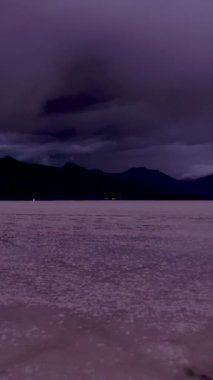 Uyuni Tuz Düzlükleri. Salar De Uyuni. Hava görüntüsü. Altiplano, Bolivya. Yağmur mevsimi. Dramatik ve Fırtınalı Gökyüzü. İnsansız hava aracı alçaktan uçuyor. Geniş açı. Dikey Video
