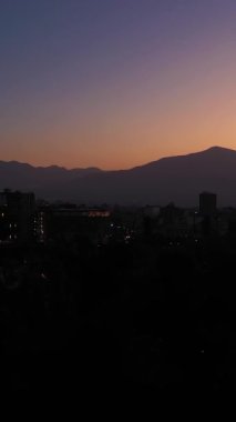 Santiago City, Sabah Alacakaranlığı ve And Dağları 'nda. Mavi Saat. Hava görüntüsü. Şili. Drone yukarı doğru uçuyor. Dikey Video