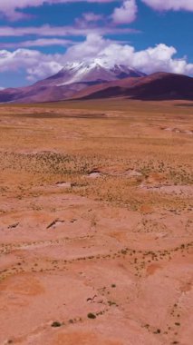 Ollague Volkanı ve Kaya oluşumları. Bolivya 'da. Bulutlu Mavi Gökyüzü. Hava görüntüsü. Drone İleri Uçuyor, Eğil. Şutu göster. Dikey Video