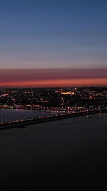 Ponte 25 de Abril Askılık Köprüsü Lizbon 'u Almada' ya bağlıyor. Portekiz. Hava görüntüsü. Yörüngede. Dikey Video