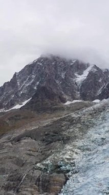 Aiguille du Midi Dağı ve Fransız Alplerinde Bossons Buzulu. Hava görüntüsü. Fransa. Yörüngede. Dikey Video