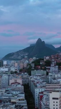 Cantagalo ve Pavao-Pavaozinho Favelas. Rio de Janeiro, Brezilya. Hava görüntüsü. İnsansız hava aracı yandan uçuyor. Dikey Video