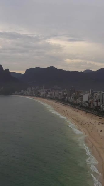 リオデジャネイロ市 イパネマビーチと大西洋のサンセット アリアルビュー ブラジル ドローン フライがビーチに向かって バーティカルビデオ — ストック動画