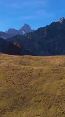 Tepeler ve Dağlar. İsviçre Alpleri, İsviçre. Hava görüntüsü. Drone Yana ve Yukarı Uçuyor. Dikey Video