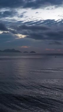 Sabah Alacakaranlığı 'nda Rio de Janeiro yakınlarındaki Tepeler ve Okyanus. Hava görüntüsü. Brezilya. İnsansız hava aracı yandan uçuyor. Dikey Video