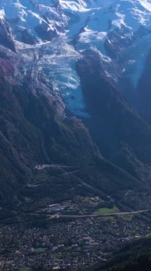 Güneşli bir günde Chamonix Vadisi, Mont Blanc ve Aiguille du Midi Dağları. Fransız Alpleri, Fransa. Hava görüntüsü. İnsansız Hava Aracı Yana Uçuyor, Eğil. Dikey Video