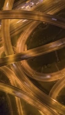 Karmaşık Yol Kavşağı ve Gece Araba Trafiği. Üstgeçit. Hava Dikey Tepetaklak Hiper Hata. Drone yukarı doğru uçuyor. Dikey Video