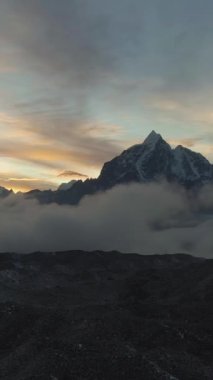 Taboche ve Cholatse Dağı Renkli Gün Batımında. Himalaya, Nepal. Hava görüntüsü. Drone geriye doğru uçuyor. Dikey Video