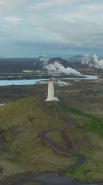 Jeotermal bölgedeki Reykjanes Deniz Feneri. İzlanda. Hava görüntüsü. Drone yörüngede. Dikey Video