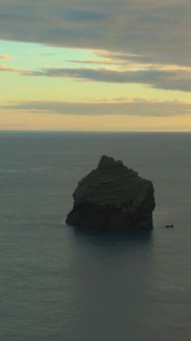 Günbatımında Denizde Uçurum. Reykjanes Yarımadası. İzlanda. Hava görüntüsü. Drone yörüngede. Dikey Video