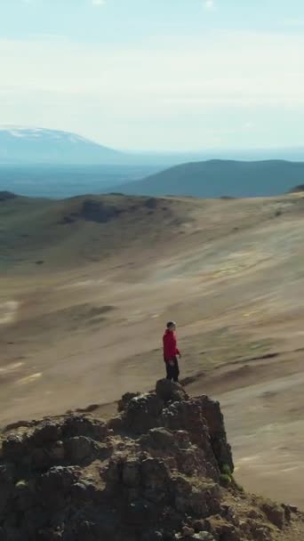 阳光明媚的时候 人类旅行者站在Hverir地区山顶上 空中景观 无人机是在轨道上垂直录像 — 图库视频影像